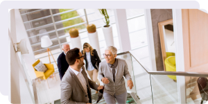 A group of professionals scale a modern staircase in an office building.